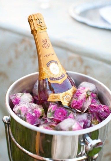 Rose Petal Ice Cubes are chilling this bottle of champagne in style. Read the post for more Valentine's Day Party Decorations